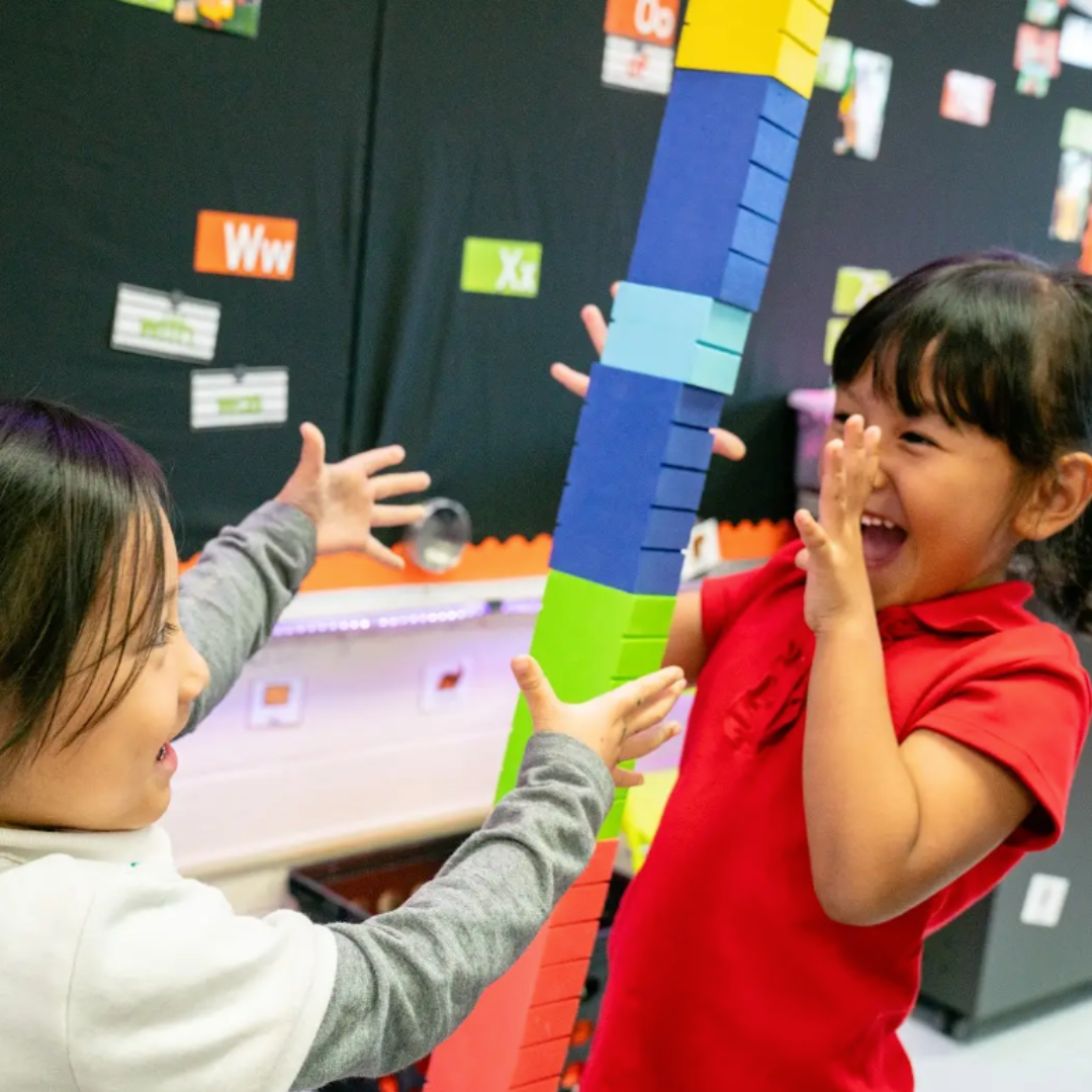 Two girls building a Math Stackers tower