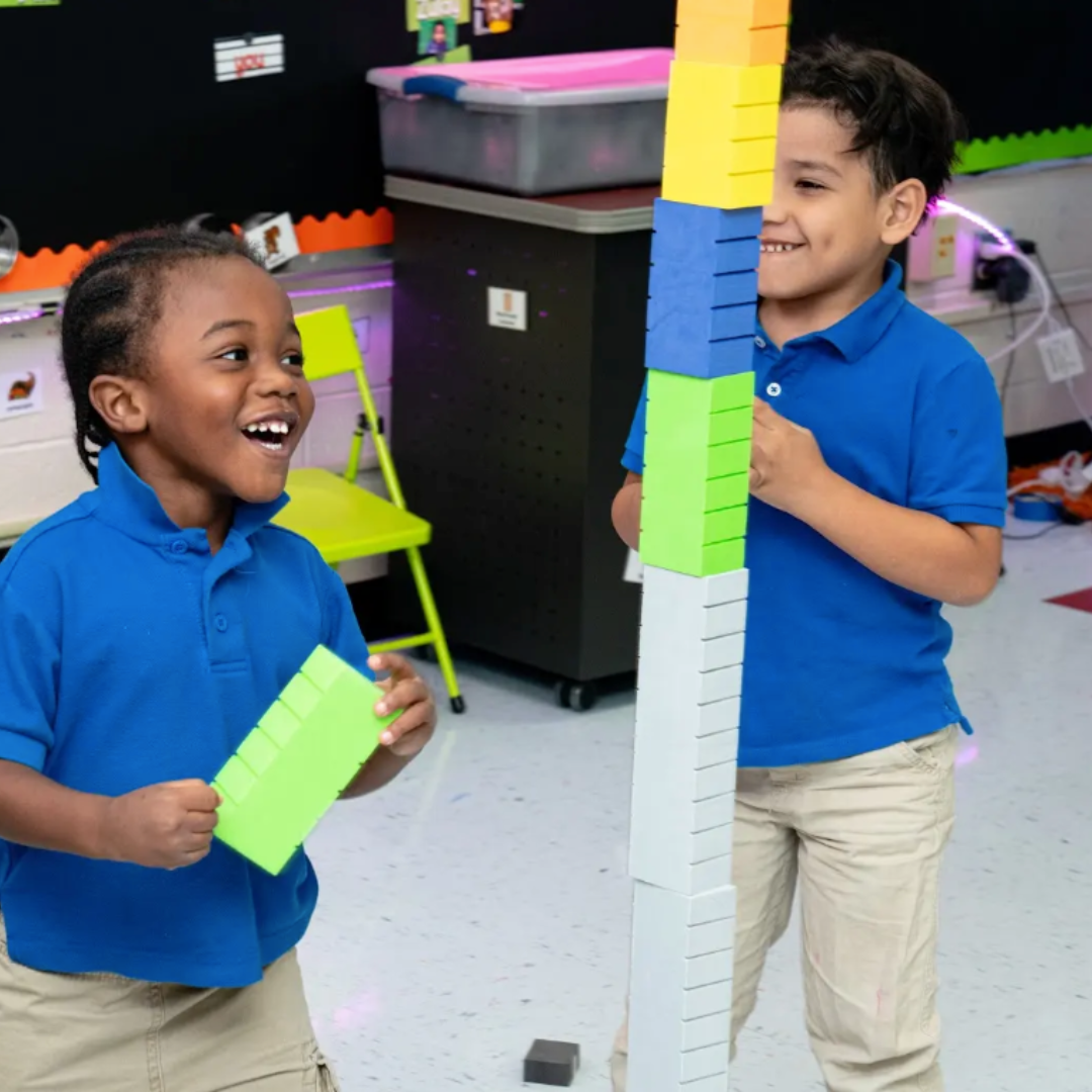 Two children playing with Math Stackers in a classroom setting.