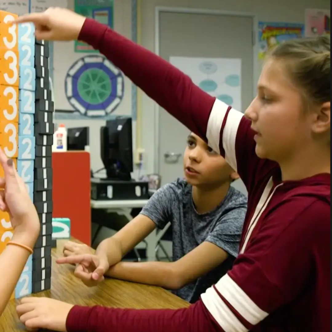 Two children interacting with Math Stackers in a classroom setting.