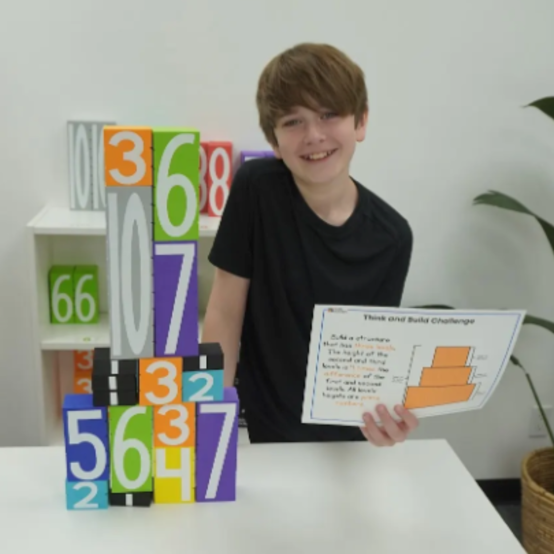 Child with Math Stackers and a challenge card in a home setting